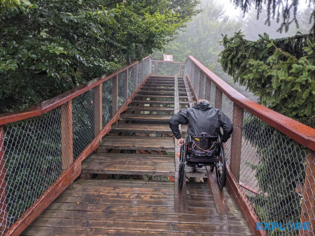 Nick in a wheelchair on the narrow ramp going upstairs in the rain