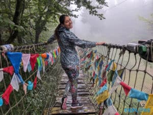Kamila smiling on the Himalayan Path, surrounded by colourful flags