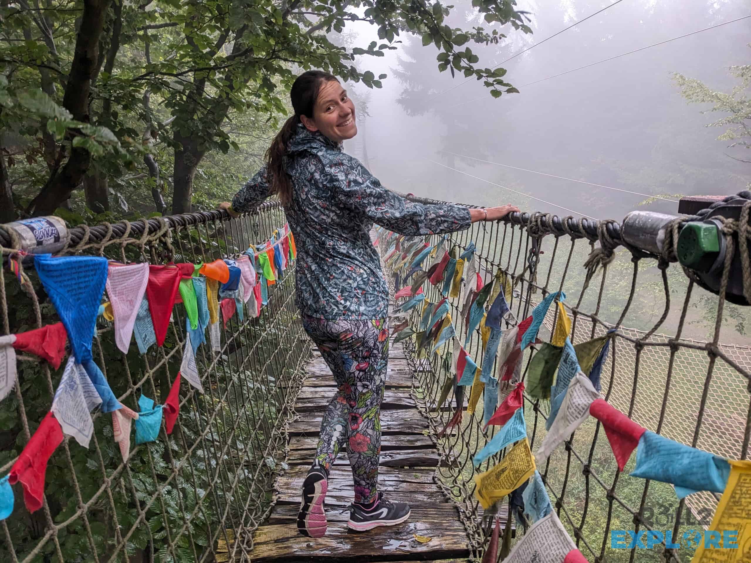 Kamila smiling on the Himalayan Path, surrounded by colourful flags