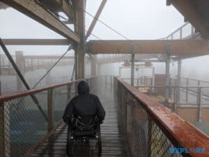 Nick in a wheelchair on the Stezka Valaska walkway in he rain